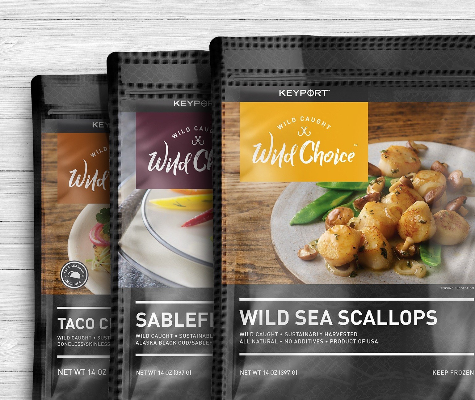 Three packages of seafood on a grey background