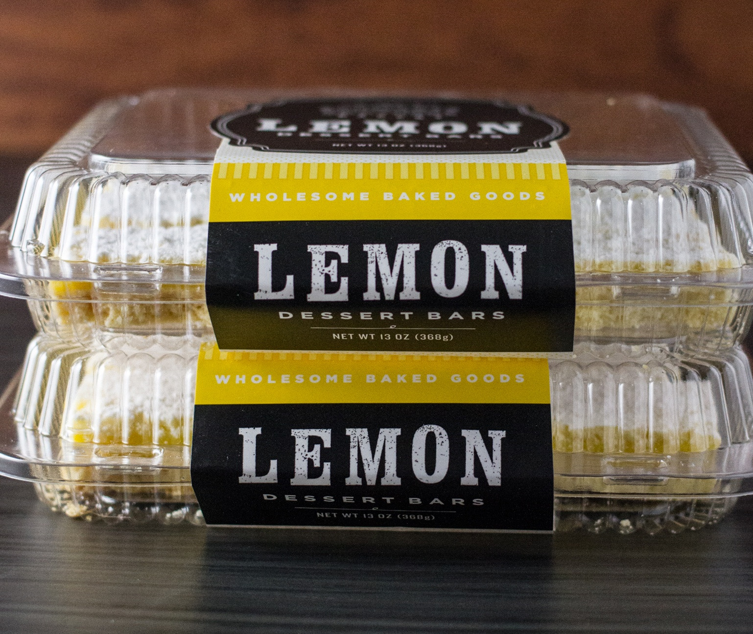 Two Schwartz Brothers Bakery lemon dessert bars clamshell packages stacked on top of each other on a countertop